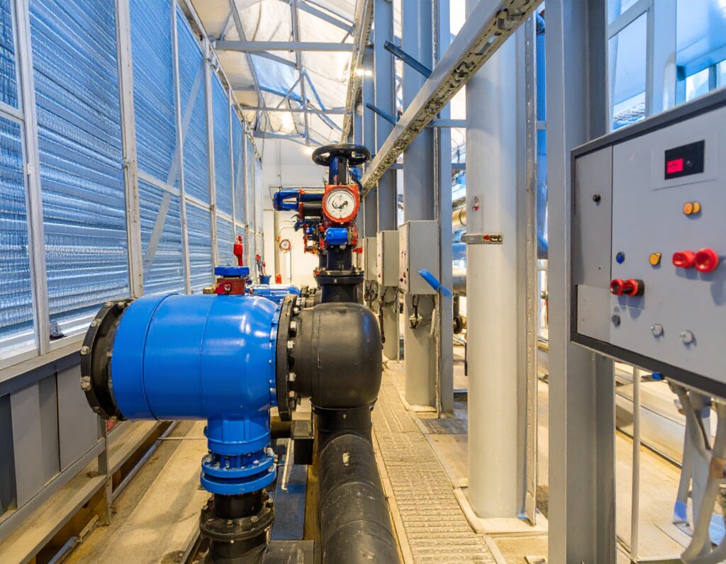 Close-up view of a modern mechanical room with insulated industrial pipes, valves, and pressure gauges, highlighting advanced pipe insulation for HVAC efficiency.
